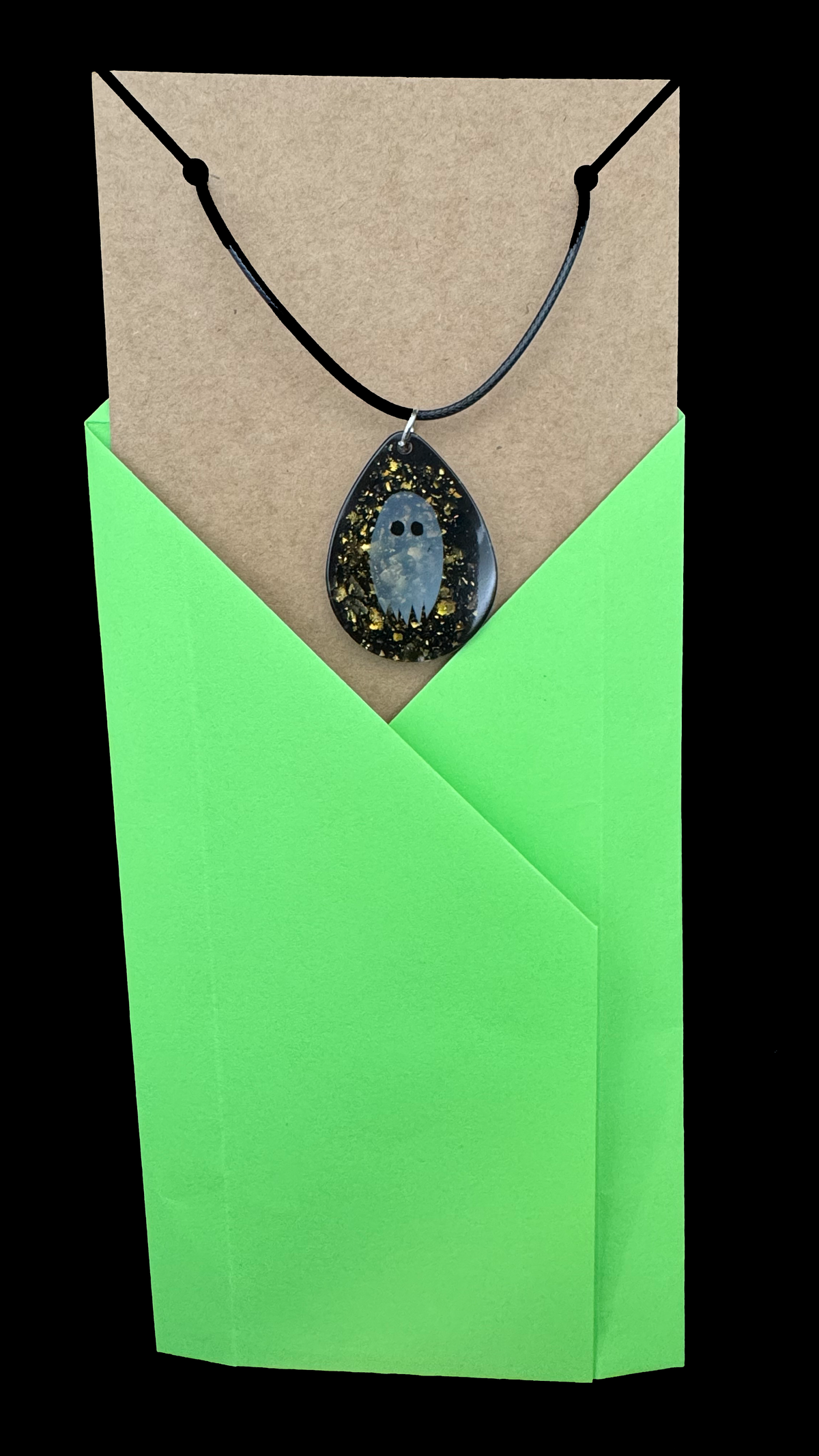 Necklace - A Teardrop Shaped Resin Charm Features A Paper Ghost Floating on A Sparkly Black Background